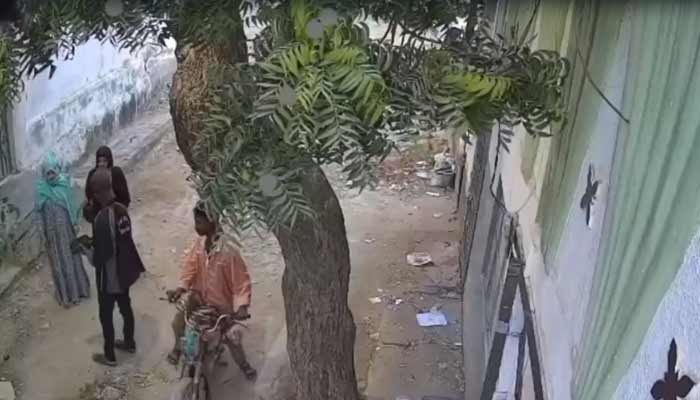 The photograph shows two men robbing women in Karachis Orangi area.— Screengrab/GeoNews