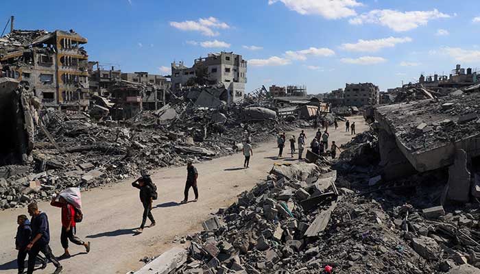 Palestinians walk past the rubble of destroyed buildings, amid a ceasefire between Israel and Hamas, in Gaza City, October 14, 2025. — Reuters