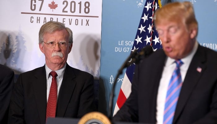 National Security Advisor John Bolton listens as US President Donald Trump speaks to reporters on June 9, 2018, during the G7 Summit in La Malbaie, Quebec, Canada. — AFP