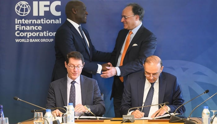 Federal Minister for Finance and Revenue Senator Muhammad Aurangzeb and IFC Managing Director Makhtar Diop exchange greetings as State Bank of Pakistan Governor Jamil Ahmad and an IFC official sign a swap agreement. — X/@Financegovpk
