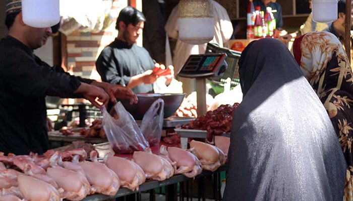 A woman buys chicken in Quetta, on March 1, 2025. — INP