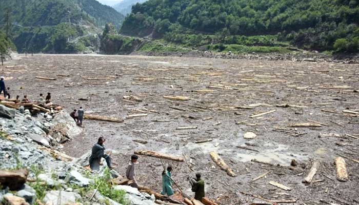 Locals collect wood from Noseri Dam near Muzaffarabad after flash floods. — AFP/File