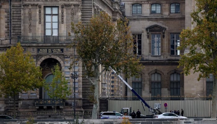 Police officers work next to a crane and a window believed to have been used in what the French Interior Ministry said was a robbery at the Louvre museum during which jewellery was stolen, in Paris, France, October 19, 2025. — Reuters