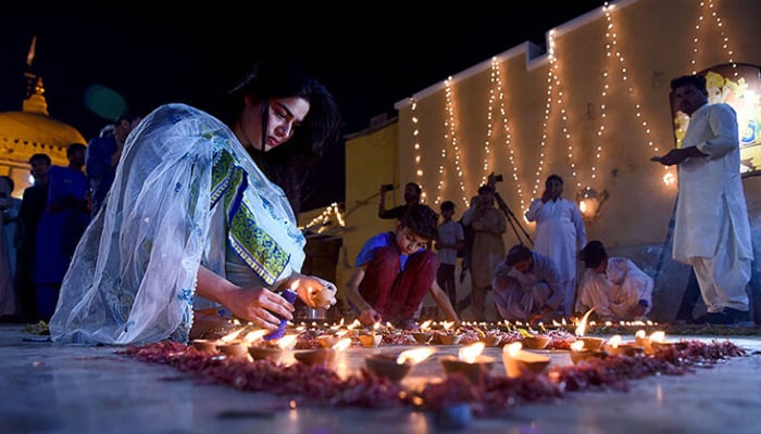 A young woman from the Hindu community lights diyas amid Diwali celebrations in Pakistan. — APP/File