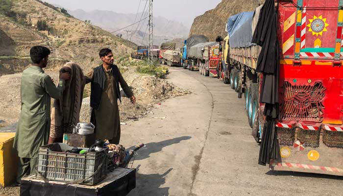 A tea vendor stands near the stalled vehicles near the closed Pakistan-Afghanistan border town of Torkham on October 19, 2025, after cross-border clashes between the two countries. — AFP