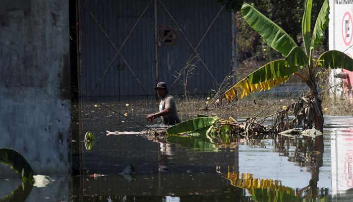 A man wades through floodwaters in the aftermath of a river overflow caused by torrential rains, in Alamo, Mexico, October 17, 2025.— Reuters