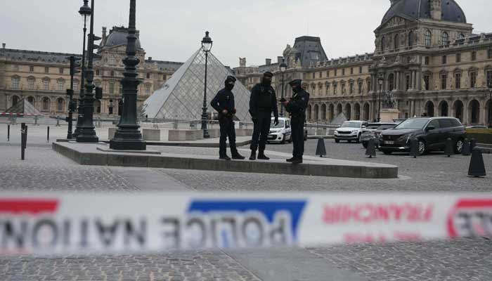 French police officers patrol in front of the Louvre Museum after it was robbed, with the Louvre Pyramid designed by Ieoh Ming Pei in the background, in Paris on October 19, 2025.— AFP