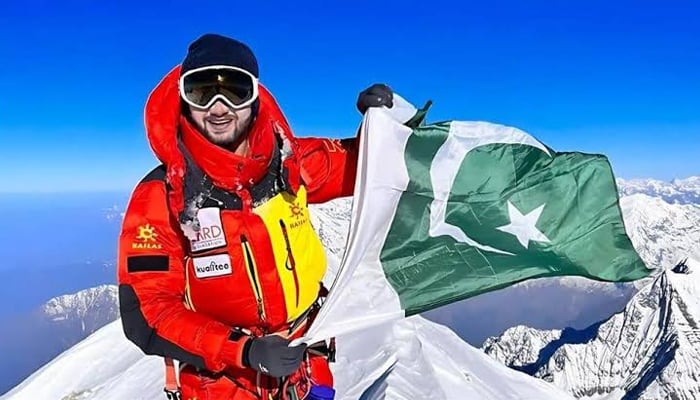 Pakistani mountaineer Shehroze Kashif posed with the national flag on a mountain top. — X@Shehrozekashif2