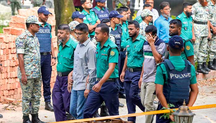 Police personnel escort detained army officers to the International Crimes Tribunal court in Dhaka on October 22, 2025, over charges of crimes against humanity. — AFP
