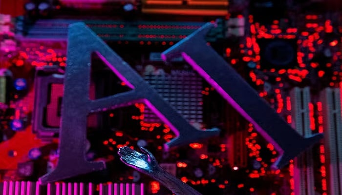 AI (Artificial Intelligence) letters and a robot hand are placed on a computer motherboard in this illustration created on June 23, 2023. — Reuters