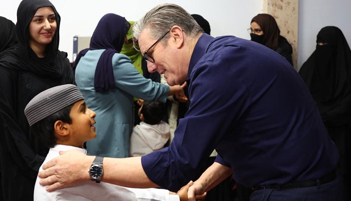UK Prime Minister Keir Starmer shakes hand with a child during his visit to Peacehaven Mosque in East Sussex. — reporter