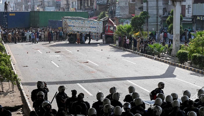 Supporters of the Tehreek-e-Labbaik Pakistan (TLP) party shout slogans near their party headquarters, as authorities blocked the road with shipping containers, in Lahore on October 9, 2025, ahead of their pro-Palestinian march towards Islamabad. — AFP