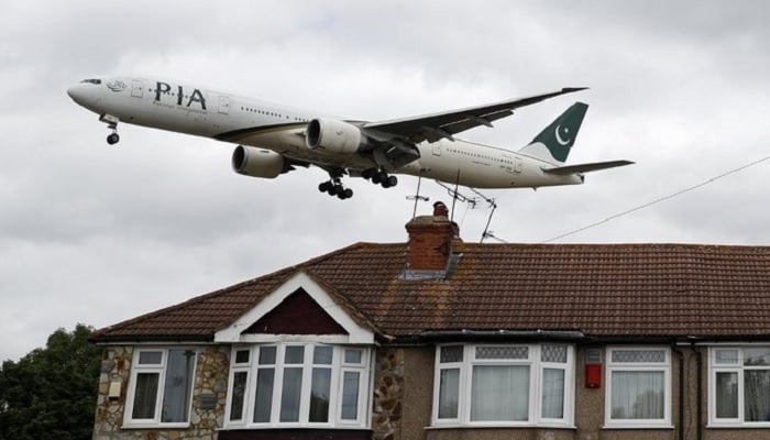 A Pakistan International Airlines (PIA) Boeing 777 comes in over houses to land at Heathrow Airport in west London on June 8, 2020.—AFP