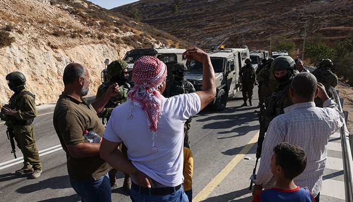 Palestinian farmers argue with Israeli security forces after their harvest was disrupted by Israeli settlers and halted by Israeli security forces in Sa´ir village, near the Israeli occupied West Bank city of Hebron, on October 23, 2025. — AFP