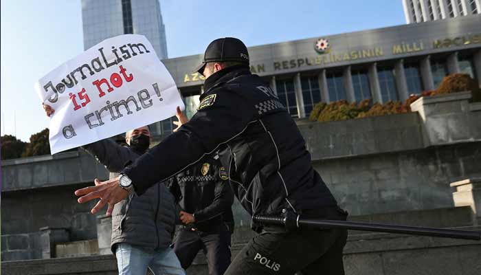 Police officers restrain a protester during a rally of journalists against a new media bill, in front of the Parliament building in Baku, Azerbaijan, on December 28, 2021. — Reuters