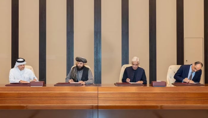 Afghan Defence Minister, Mullah Mohammad Yaqoob Mujahid and Pakistans Defence Minister, Khawaja Asif sign documents of a ceasefire agreement, during a negotations meeting mediated by Qatar and Turkiye, in Doha, Qatar, October 19, 2025. — Reuters
