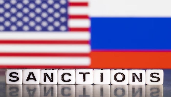 Plastic letters arranged to read Sanctions are placed in front of the flag colours of the US and Russia in this illustration taken February 28, 2022. — Reuters