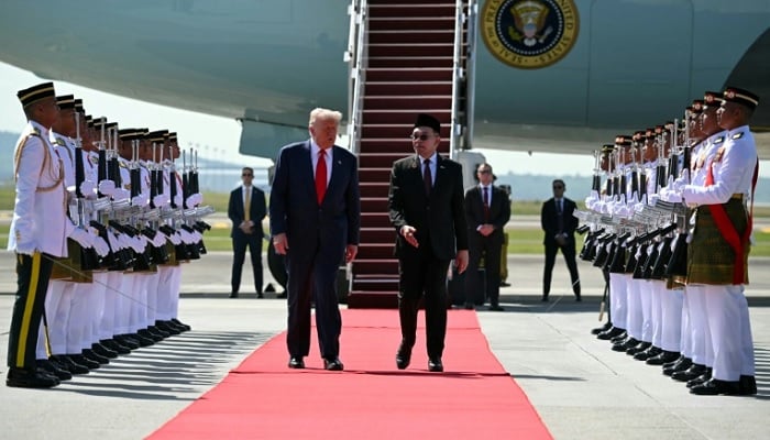 US President Donald Trump walks with Malaysian Prime Minister Anwar Ibrahim after arriving at Kuala Lumpur International Airport on October 26, 2025. — Reuters