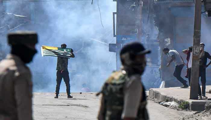 A protester (C-L) waves a Kashmiri flag during clashes with government forces in Batamaloo area of Srinagar on September 17, 2020 — AFP/Files