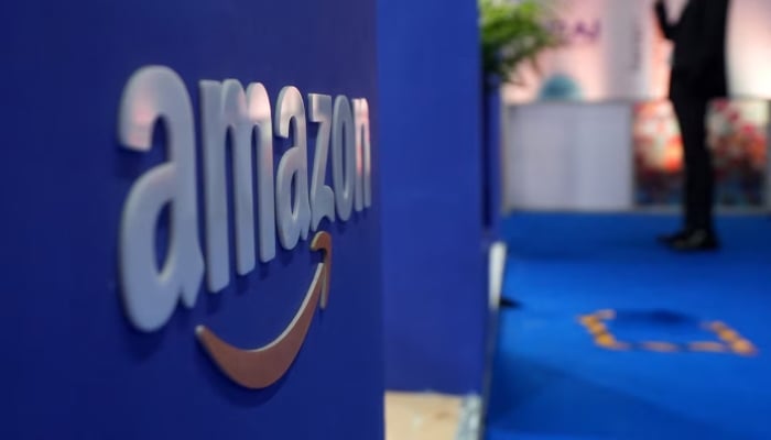 A visitor stands near a logo of Amazon during the annual Retail Leadership Summit in Mumbai, India, February 27, 2025. — Reuters