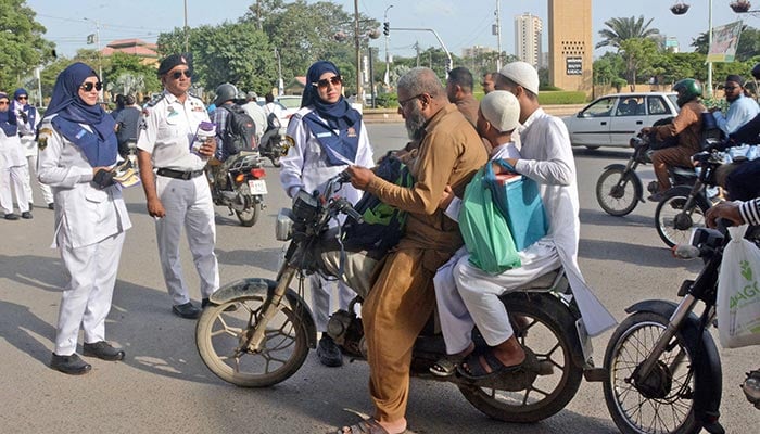 Karachi traffic police personnel speak to a man during an awareness campaign in Karachi, on September 20, 2025. — Online