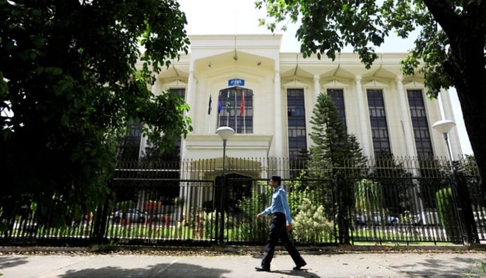 A policeman walks past the Federal Board of Revenue (FBR) office building in Islamabad, August 29, 2018. — Reuters