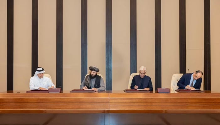 Defence Minister, Khawaja Asif and Afghan Defence Minister, Mullah Mohammad Yaqoob Mujahid sign documents of a ceasefire agreement, during negotations meeting mediated by Qatar and Turkiye, in Doha, Qatar, October 19, 2025. — Reuters