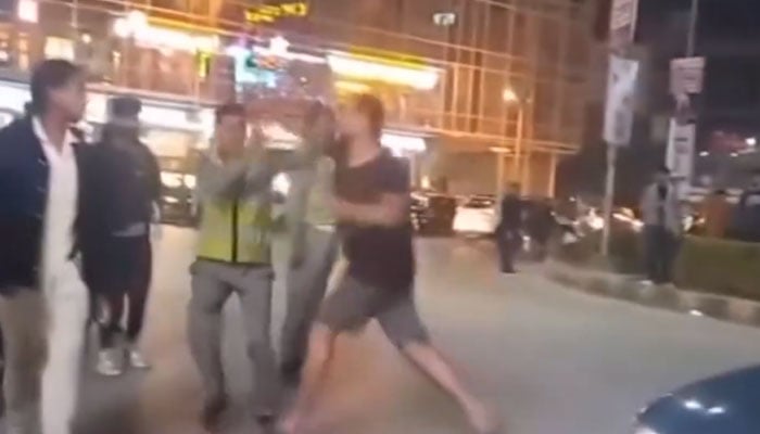 A man assaults traffic police personnel in Islamabad on November 1, 2025. — Screengrab X@itxAhmad7744