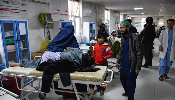 An Afghan burqa-clad woman sits beside an earthquake victim receiving treatment at a hospital in Mazar-i-Sharif on November 3, 2025. — Reuters