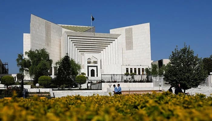 Police officers walk past the Supreme Court building in Islamabad on April 6, 2022. — Reuters