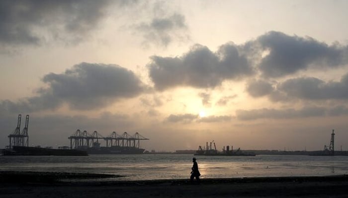 A man is silhouetted as he walks amid hot and humid weather at breakwater along port area in Karachi, Pakistan May 7, 2018. — Reuters