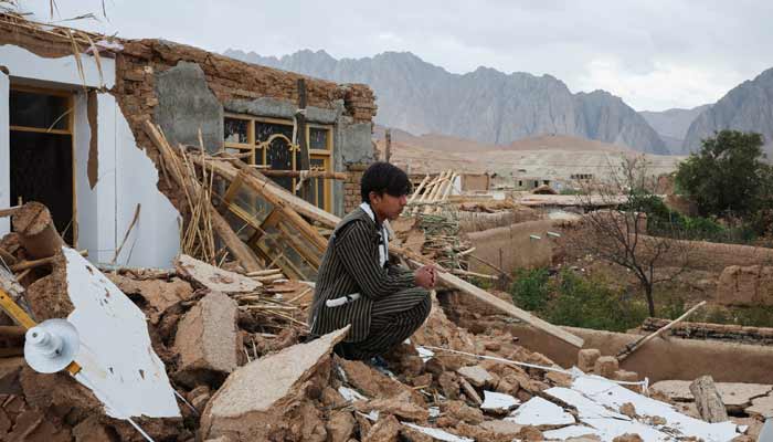 A boy sits next to his damaged house, in the aftermath of an earthquake, in Samangan province, Afghanistan, November 4, 2025.— Reuters