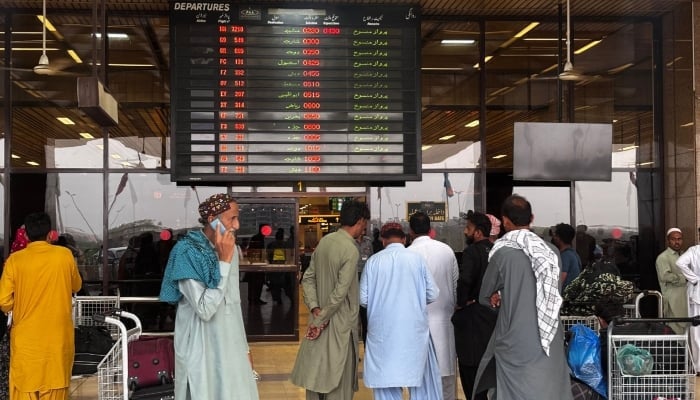 Passengers wait at Jinnah International Airport after all domestic and international flights were cancelled in Karachi on May 7, 2025. — AFP