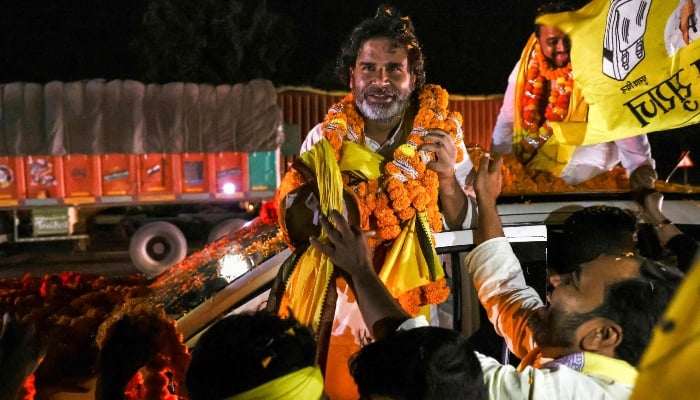 In this photograph taken on October 30, 2025, supporters of Prashant Kishor, founder of the Jan Suraaj party, welcome him with garlands during his roadshow at Darbhanga, ahead of assembly elections in Indias Bihar state. — AFP