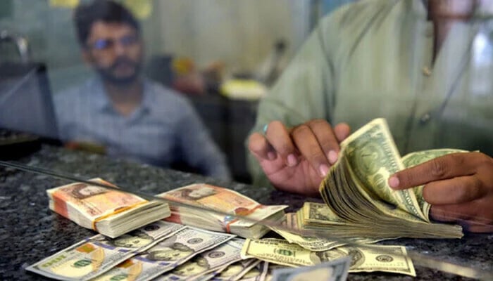 A money dealer counts dollar bills at an exchange company. — Reuters