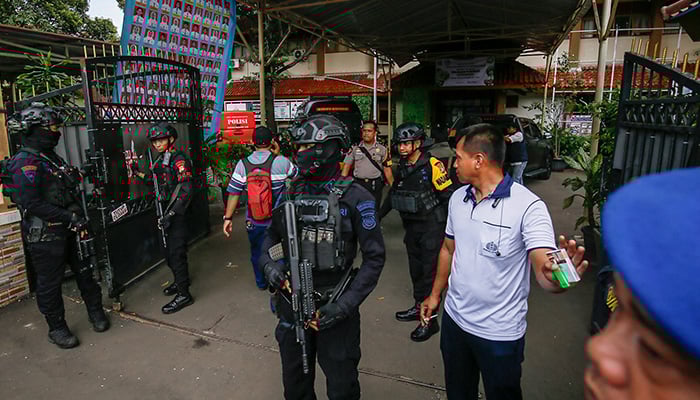 Bomb squad officers stand guard at the entrance of a school in Jakarta on November 7, 2025. — AFP