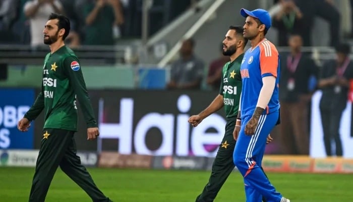 Pakistans captain Salman Agha (Left) and his Indian counterpart Suryakumar Yadav (Right) walk to the field before the start of the Asia Cup 2025 final at the Dubai International Stadium on September 28, 2025. — AFP