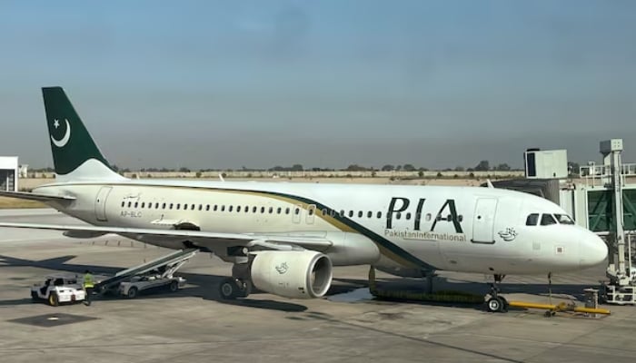 View of a Pakistan International Airlines (PIA) passenger plane, taken through a glass panel, at Islamabad International Airport, October 3, 2023. — Reuters