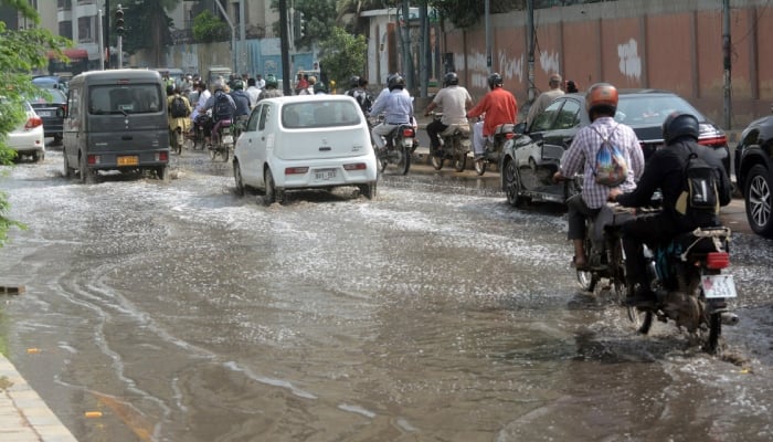 Commuters wade through stagnant sewerage water near Frere Police Station, Karachi, October 7, 2025. — APP