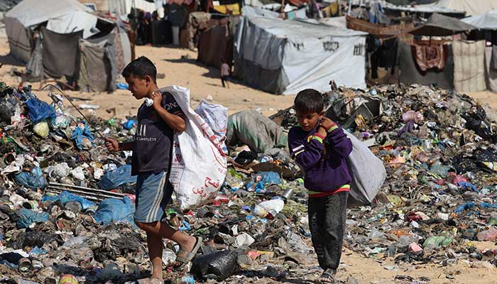 Palestinian children look through garbage near a landfill site in Khan Younis, southern Gaza Strip, October 30, 2025. — Reuters