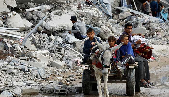 Palestinians ride on a donkey-drawn cart amid the rubble of destroyed buildings, during a ceasefire between Israel and Hamas, in Jabalia, northern Gaza Strip, on November 4, 2025. — Reuters