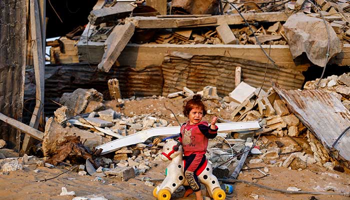A Palestinian child plays with a toy amid the rubble of destroyed buildings, amid a ceasefire between Israel and Hamas, in Jabalia, northern Gaza Strip, November 6, 2025. — Reuters