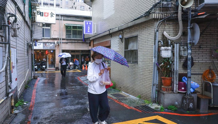 A woman holds an umbrella while walking on a road, as Typhoon Fung-wong approaches in Taipei, Taiwan, November 11, 2025. — Reuters