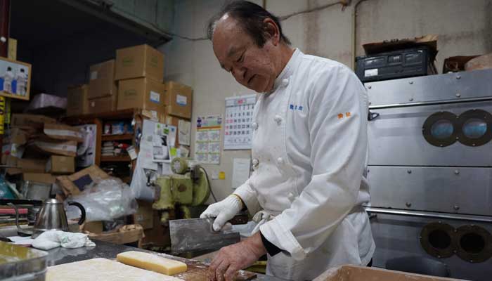 Bear attack victim Keiji Minatoya, a pastry maker, prepares his speciality butter mochi at home in Kita-Akita, Akita prefecture on October 25, 2025. — AFP