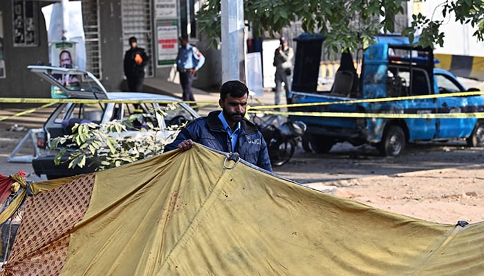 A policeman stands near the wreckage of vehicles at the cordoned-off site, a day after the suicide bombing, in Islamabad on November 12, 2025. — AFP