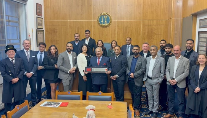 Tariq Halal Meat owner Tariq Sheikh poses with the award among others attending the ceremony. — Reporter