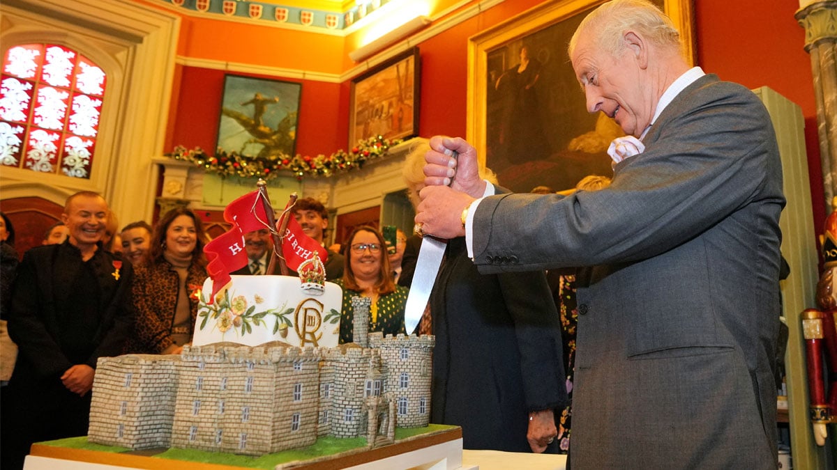 Britains King Charles holds a knife to cut a cake in the shape of the castle as he joins a celebratory reception marking Cyfarthfa Castles 200th anniversary and the Kings birthday in Merthyr Tydfil, Wales, Friday, Nov. 14, 2025. Kin Cheung/Pool via REUTERS