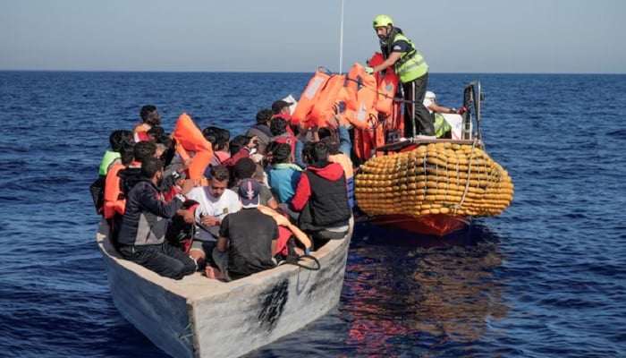 Crew members of NGO rescue ship Ocean Viking give lifejackets to migrants on an overcrowded boat in the Mediterranean Sea, October 25, 2022. — Reuters