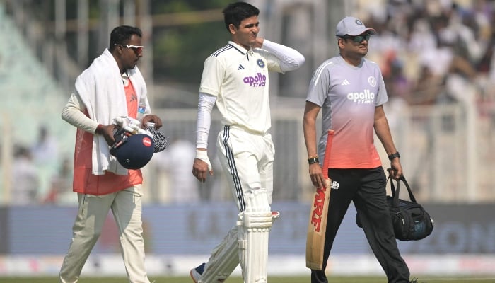 Indias captain Shubman Gill (centre) walks back to the pavilion after his injury during the second day of the first Test cricket match between India and South Africa at the Eden Gardens in Kolkata, India, on November 15, 2025. — AFP