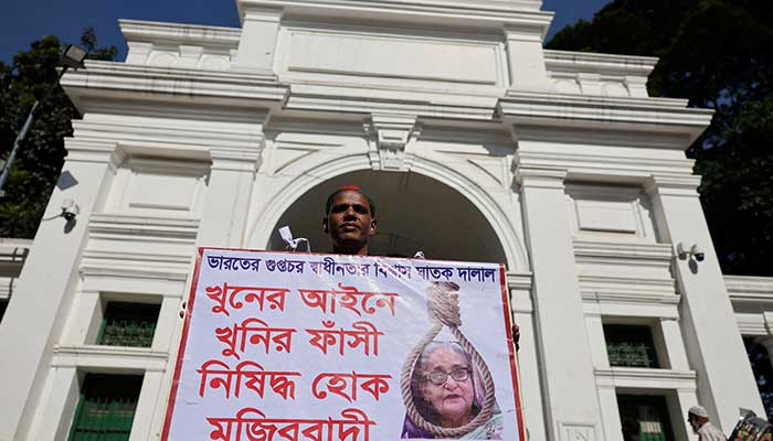 A man holds a poster in front of the court demanding the capital punishment against the ousted Prime Minister Sheikh Hasina, in Dhaka, Bangladesh, November 17, 2025. — Reuters